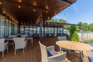 a wooden deck with tables and chairs and an umbrella at SPA Hotel Galera in Kyiv