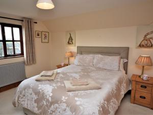 a bedroom with a large white bed with two lamps at 4 Bed in Uplowman 60110 in Uplowman