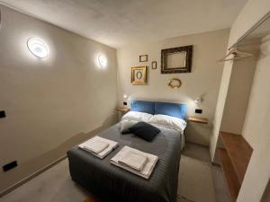 a small bedroom with a bed with towels on it at La Casa di Margot - Alloggio Blu in Murazzano