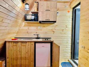 una cocina en una casa pequeña con paredes de madera en Sea Light, en Batumi
