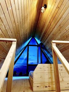 Sea Light في باتومي: غرفة نوم مع نافذة كبيرة في سقف خشبي