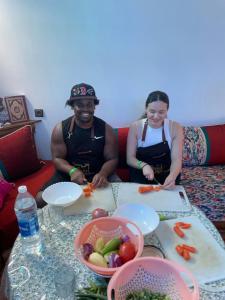 a man and a woman sitting at a table with food at kasbah souss cooking in Agadir