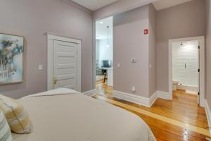 Dormitorio blanco con cama y pasillo en Condo in Downtown Hot Springs Near Bathhouse Row!, en Hot Springs