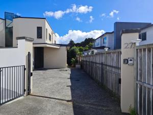 een steegje tussen twee huizen met een hek bij Vegans on Lillington in Auckland