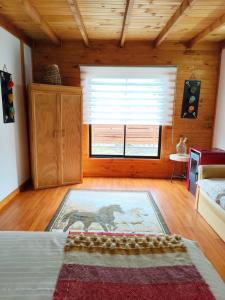 a room with a bed and a large window at Departamento acogedor in Quellón