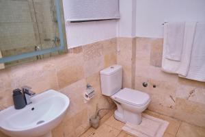 uma casa de banho com um WC branco e um lavatório. em Apartment 8 em Acra
