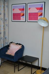 uma sala de estar com uma cadeira azul e um candeeiro em Apartment 8 em Acra