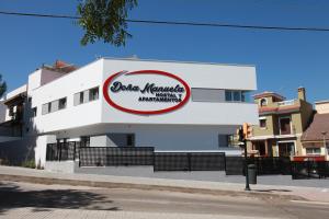 Un edificio con un cartel al costado. en Hostal Doña Manuela, en Málaga
