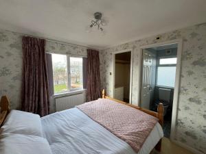 a bedroom with a bed and a window at 2 Bedroomed Lodge with Private Garden in Penrith
