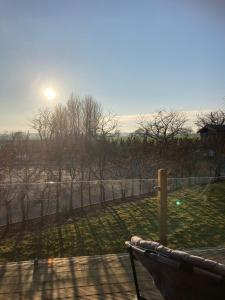 a bench in a park with the sun in the background at 2 Bedroomed Lodge with Private Garden in Penrith