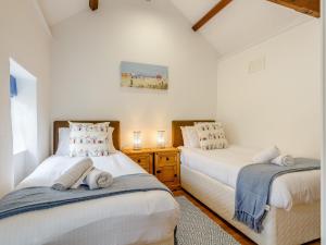 two twin beds in a room with white walls at 2 Bed in Falmouth 78620 in Penryn