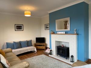 a living room with a couch and a fireplace at Carrick Beg Self Catering Holiday Accommodation with Hot Tub in Sulby