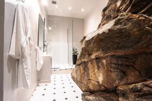 bagno con parete in pietra e bagno con doccia. di Oikia Classic House a Kavala