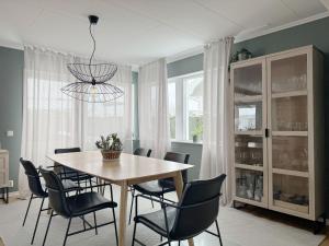 une table à manger avec des chaises et un lustre dans l'établissement High standard villa in historic Grebbestad, à Grebbestad