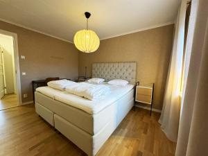 1 dormitorio con 1 cama blanca grande con lámpara de araña en High standard villa in historic Grebbestad en Grebbestad