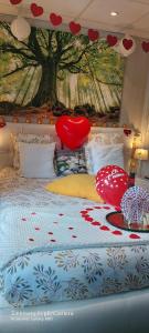 a bedroom with a bed with red hearts on it at Péniche Morgane 2 chambre d'hôtes in Cambrai