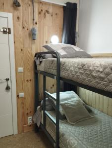 a room with two bunk beds and a door at PETITE CHAMBRE D'HÔTES LITS SUPERPOSES avec SALLE DE BAINS PRIVEE CHEZ CATHERINE A REUS in Reus