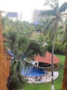 a view of a pool from a hotel with palm trees at Suit Junior Emano 410 in Ixtapa +9 photos