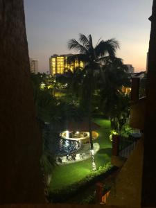 vistas a una piscina con palmeras y a un edificio en Suit Junior Emano 410 en Ixtapa