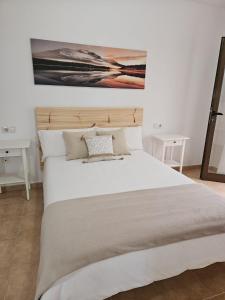 a bedroom with a bed with a painting on the wall at Casa La Molina in San Bartolomé