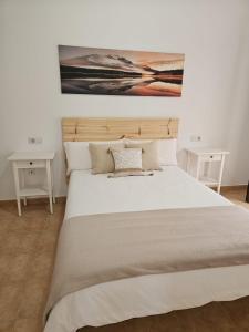 una camera da letto con un grande letto con due tavoli bianchi di Casa La Molina a San Bartolomé