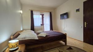 a bedroom with a bed with a window and a table at Villa Roua in Bran