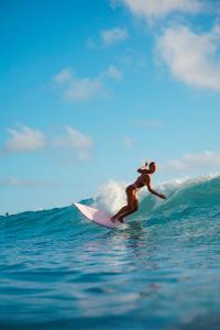 una mujer montando una ola en una tabla de surf en el océano en Lia Del Mar en La Sabrosa