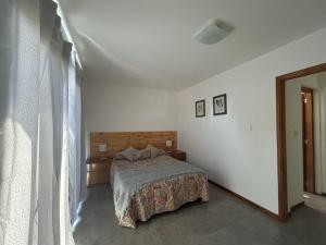 a bedroom with a bed in a white room at La Juana in Esquel