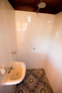 La salle de bains blanche est pourvue d'un lavabo et de carrelage. dans l'établissement Lia Del Mar, à La Sabrosa