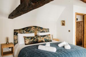 1 dormitorio con 1 cama con toallas en Crippens, Home Hotel Central 5 star Historic Free Parking EV, inglenook fireplace en Canterbury