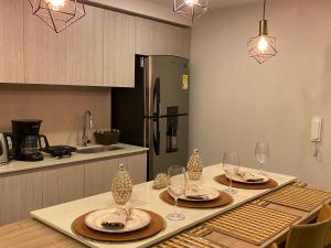 uma cozinha com uma mesa com pratos e copos de vinho em Dominique Cartagena, Beautiful 2 Bedroom Apartment em Cartagena de Indias