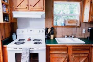 uma cozinha com um fogão branco e um lavatório em Tiny House em Hulbert