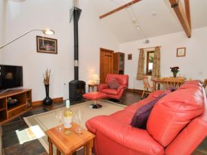 a living room with a red couch and a fireplace at 2 Bed in Sherborne FOLWO in Long Burton