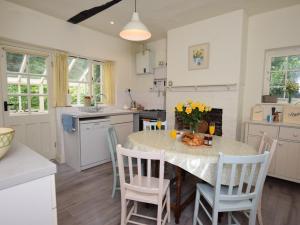 a kitchen with a table and chairs and a kitchen with white cabinets at 4 bed in Lyndhurst 57407 in Lyndhurst