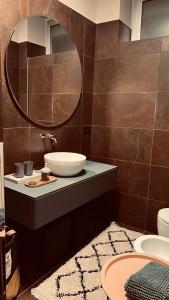 ein Bad mit einem Waschbecken und einem Spiegel in der Unterkunft Room Manzoni 37 in Cremona