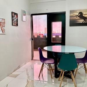 Un comedor con una mesa y sillas moradas. en Pôr do sol, en Palmas