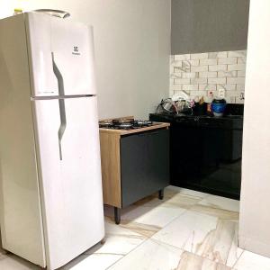 Una cocina con un refrigerador blanco y una estufa. en Pôr do sol, en Palmas
