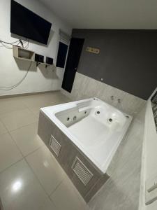 a large bath tub in a room with a tv at Hotel Select Medellin in Medellín
