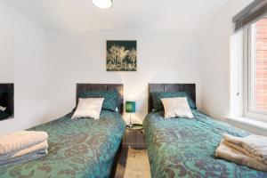 two beds sitting next to each other in a bedroom at Deluxe 2 bed flat w/free parking in High Wycombe