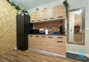 a kitchen with wooden cabinets and a black refrigerator at Vintage room in Gdańsk