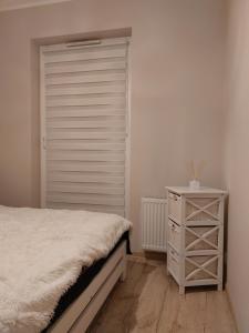 a bedroom with a bed and a white closet at Grey Tuwima in Olsztyn