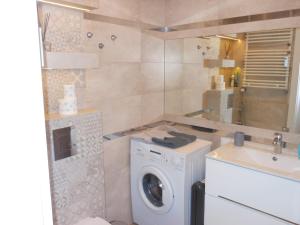 uma casa de banho com uma máquina de lavar roupa e um lavatório em Grey Tuwima em Olsztyn