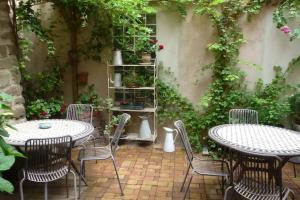 an outdoor patio with tables and chairs and plants at Studio les Hirondelles - 2 personnes à Ribeauvillé in Ribeauvillé