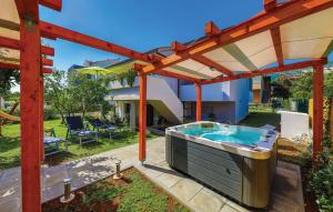 un bain à remous sous une pergola dans une arrière-cour dans l'établissement Apartman Petra, à Kaštela