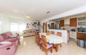 une cuisine et un salon avec une table et un canapé dans l'établissement Apartman Petra, à Kaštela