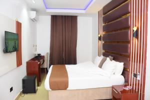 una camera d'albergo con letto e TV di Grand Seasons Hotel, Nnewichi a Nnewi