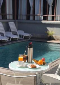 einen Tisch mit einem Tablett mit Speisen und Obst neben einem Pool in der Unterkunft Hotel Posada La Comandancia in Melo