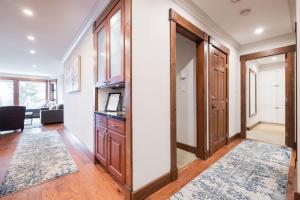 a hallway with wooden doors and a living room at Greyhawk by Outpost Whistler in Whistler