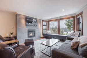 a living room with a couch and a fireplace at Greyhawk by Outpost Whistler in Whistler