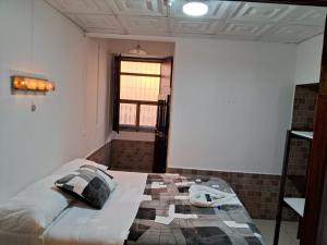 1 dormitorio con 1 cama en una habitación con ventana en Hotel Kamelot Parque Central, en Quetzaltenango